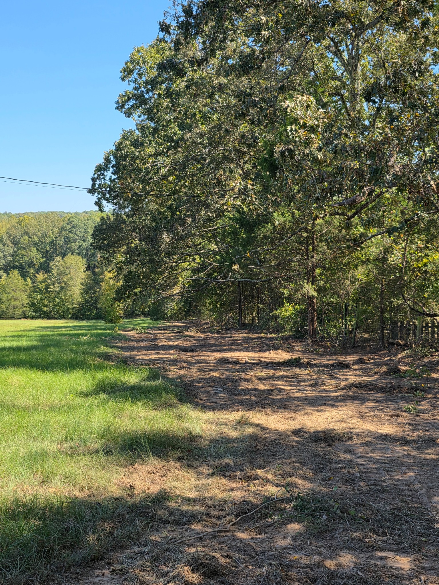Finished land clearing path beside a field